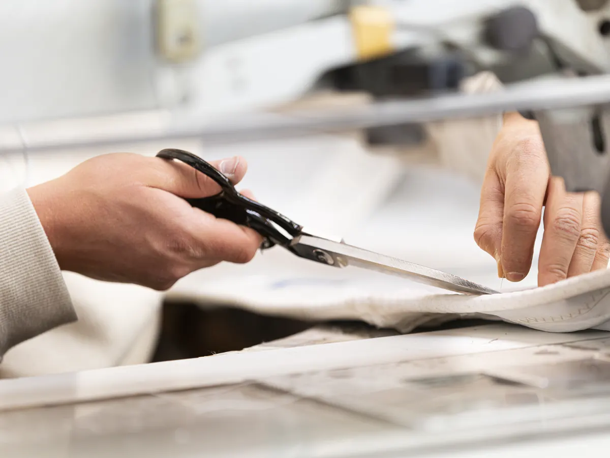 Zeildoek wordt met de hand op maat geknipt in de zeilmakerij